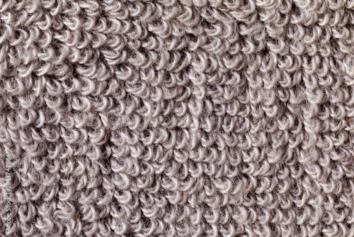 A close-up shot of a textured gray towel, showcasing its fluffy and soft fabric loops. Horizontal photo