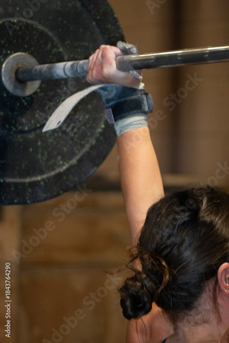 Hand Gripping Barbell With Support, Close View Of Hand Holding Heavy Weights, Focus On Hand Grip Mechanics During Lifting Process, Specifics Of Wrist Strap Use And Grip Tension In Weightlifting