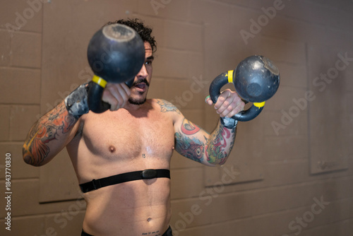 Athlete Lifting Weights, Man Trains With Kettlebells Diligently, Muscular Individual Exercises With Weighted Kettlebells Carefully, Person Without Shirt Performs Kettlebell Workout Meticulously At Gym