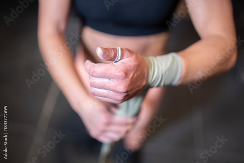 Wrist Strap Wrapping, Focused Female Weightlifter Wrapping Wrist Strap, Closeup Of Woman Wrapping Wrist Strap Before Lifting, Detailed Shot Showing Athlete Securing Wrist Strap For Deadlift At Gym