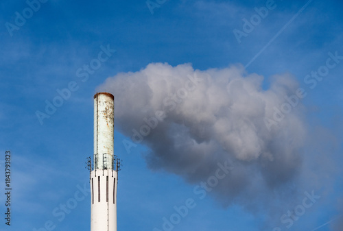 Weißer Rauch steigt aus einem Industrieschornstein