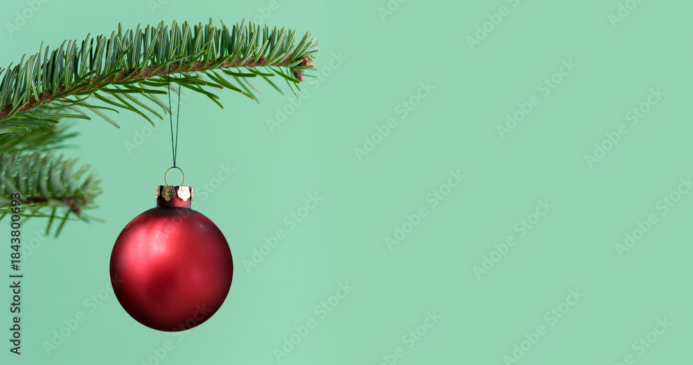 Naklejka premium Rote Weihnachtskugel an einem Tannenzweig