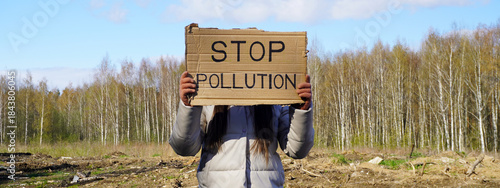 Bilde på lerret Person holding stop pollution sign near deforested area