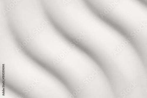 Abstract wave pattern in soft light with smooth, flowing, curved lines.