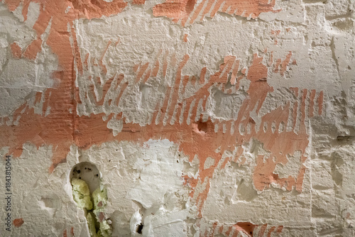 Rough texture of a wall with peeling plaster and traces of removed paint, abstract background with a natural chaos of lines and textures.
