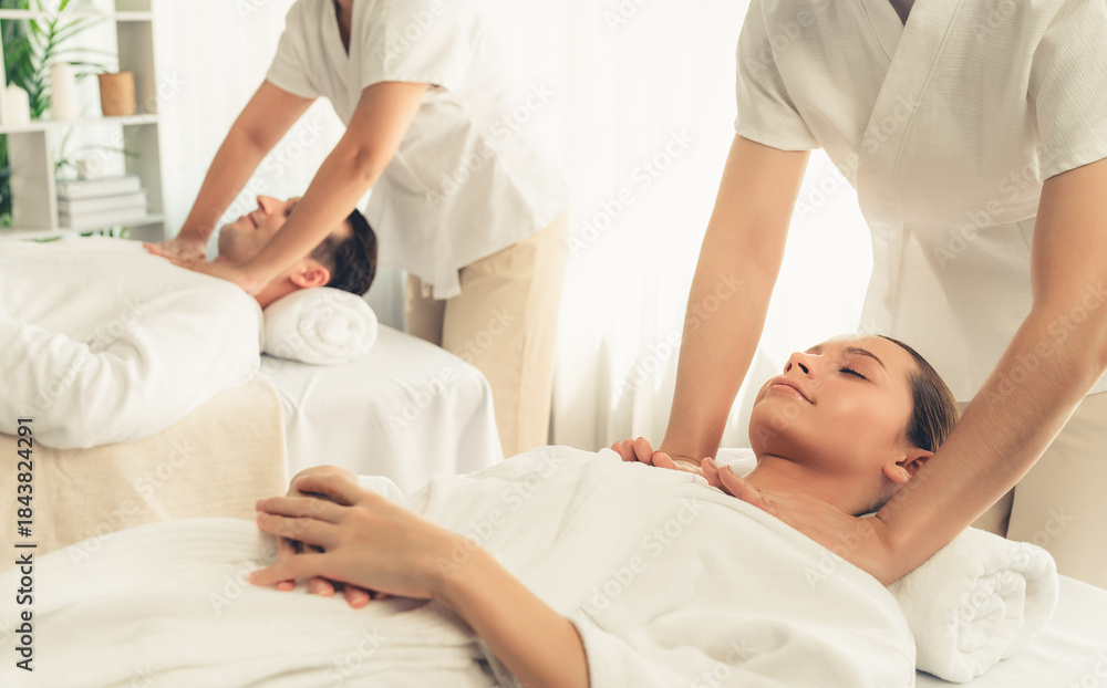 Obraz premium Caucasian couple customer enjoying relaxing anti-stress spa massage and pampering with beauty skin recreation leisure in day light ambient salon spa at luxury resort or hotel. Quiescent