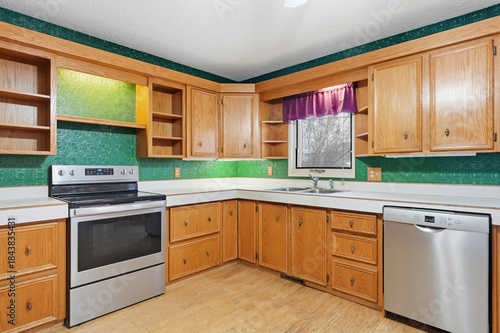 Kitchen with a green wall and wooden cabinets