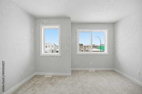 White room with two windows and a white wall