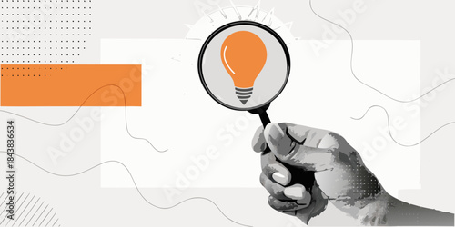 A hand holding a magnifying glass over a glowing orange light bulb