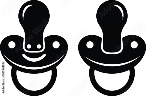 Pair of black baby pacifiers on white background