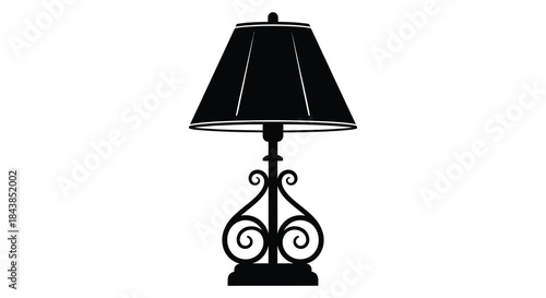 A simple black table lamp with an ornate base strikingly presented as a silhouette