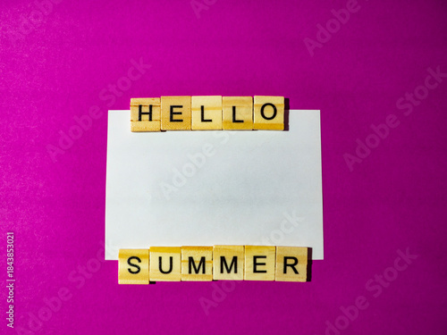 Wooden blocks spelling hello summer on pink background
