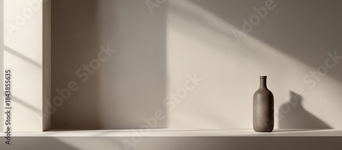 Minimalist Bottle and Shadow Play: Serene Composition with Warm Lighting.