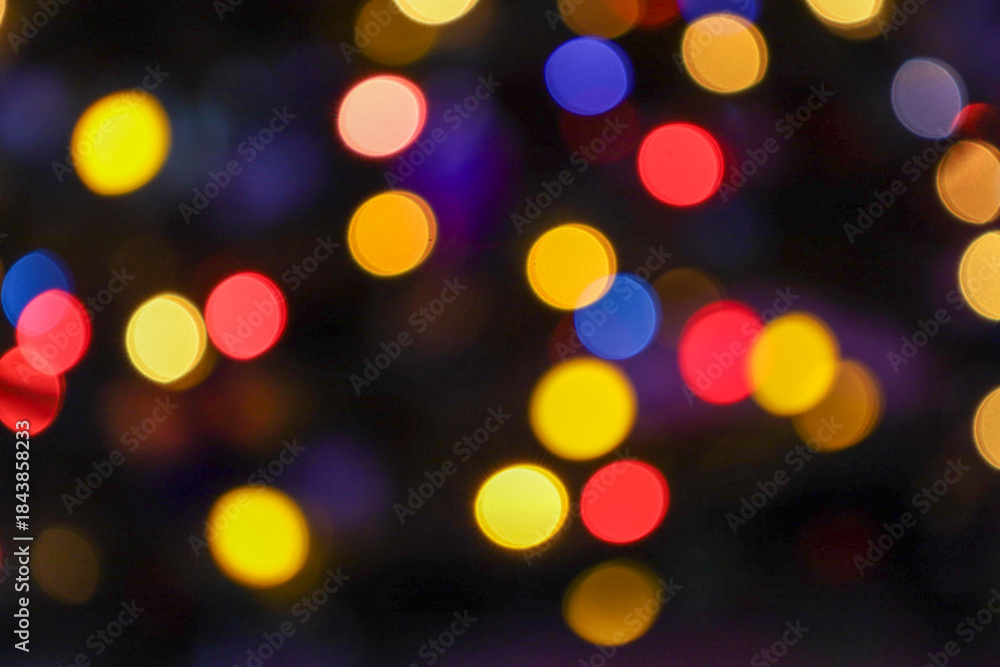 Fototapeta premium An abstract image of colorful Bokeh lights creating a soft, blurred yet vivid background of yellow, red, and blue light circles. This shimmering backdrop perfectly conveys the magical atmosphere of a 