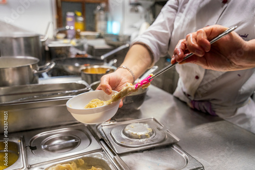 The chef at the kitchen prepare the food for the guest by moving and handling several devices to get it complete