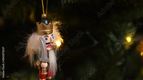 A nutcracker soldier ornament with a Christmas tree visible in the background, symbolising holiday tradition and festive Christmas spirit. 4 k video