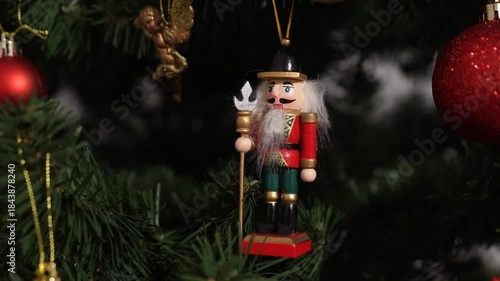 A nutcracker soldier ornament with a Christmas tree visible in the background, symbolising holiday tradition and festive Christmas spirit. 4 k video