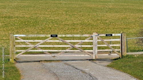 Wooden gate to a pasture with sign 