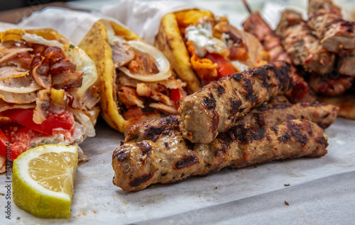 Fototapeta Naklejka Na Ścianę i Meble -  Gyro sliced meat pita bread wraps and kebab pieces, traditional street food, closeup