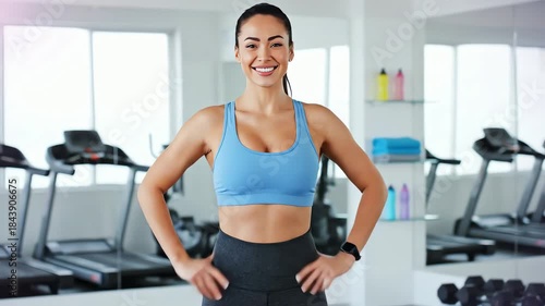 Fit woman smiles confidently in gym after losing weight and feeling better