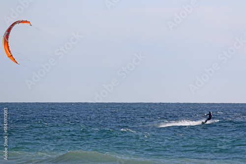 kitesurfer riding his board on the sea	