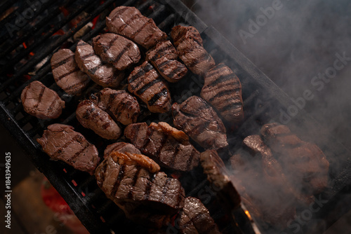 Grilled Beef Steaks Cooking on Barbecue Grill with Smoke
