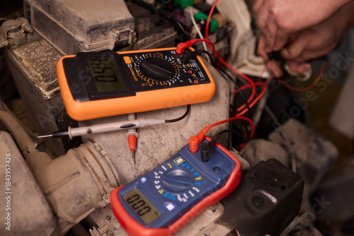 Wallpaper Mural Mechanic accurately measures vehicle wiring with specialized tools, Skilled technician conducts detailed electrical checks on car wiring in workshop environment Torontodigital.ca