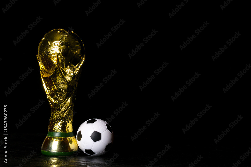 Obraz premium Moscow, Russia - December 13, 2025: FIFA World Cup Trophy with small soccer ball against black background. Free space for your text