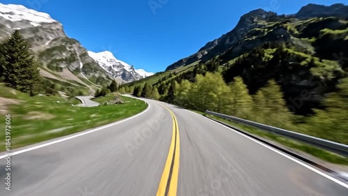 Driving through the majestic Swiss Alps on a clear summer day, a scenic road trip adventure.