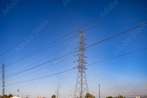 High Voltage Transmission Tower on Sunny Day with blue sky and mountain