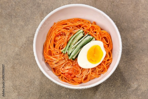 Fotografie Bibimmyeon (Korean Cold Spicy Noodles) is a Korean spicy noodle dish without broth that is usually served cold