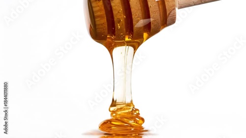 Golden Honey Dripping from Wooden Dipper on White Background.