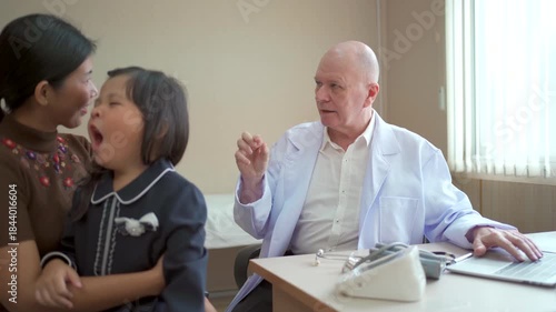 Pediatrician examining child with mother during clinic visit.