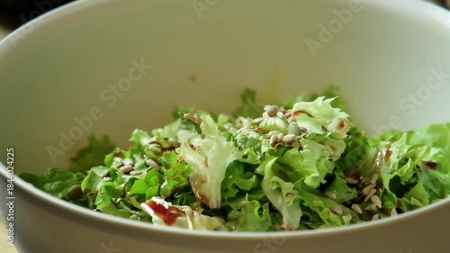 Slow motion video of seeds being sprinkled onto a fresh salad for extra texture and nutrition