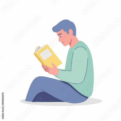 Young man sitting and reading a book intently.