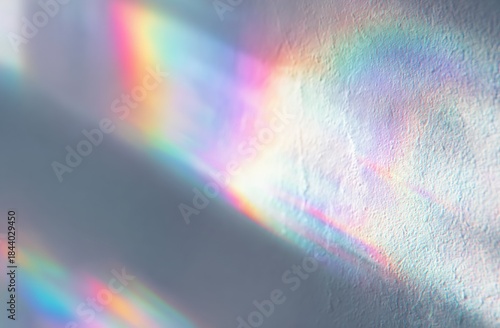 A white wall with rainbow light reflection creating viintimate apparelnt, iridescent colors and textured surface