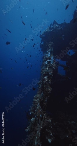 Underwater wreck ship with tropical fish in deep blue ocean