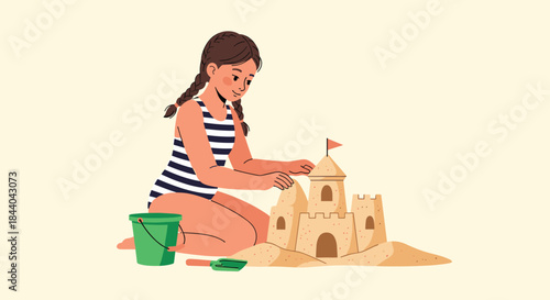 Young girl with pigtails in a striped swimsuit kneeling on a sandy beach, happily building a detailed sandcastle with a bucket and spade.
