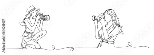 Continuous line drawing of a woman holding a camera up to her face taking a photograph in black and white