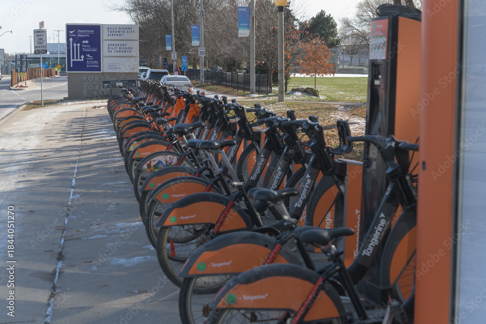 Fototapeta premium looking south on Eireann Quay incl sign at Billy Bishop Toronto City Airport and Bike Share docking station