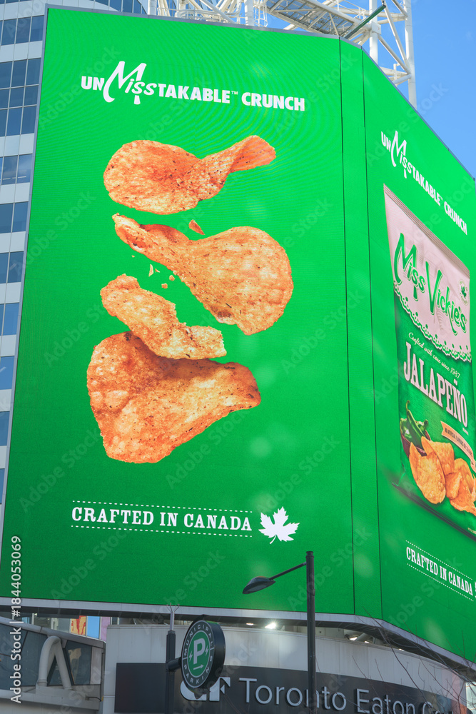 Fototapeta premium electronic sign featuring advertisement for Miss Vickie’s Jalapeño, a Canadian kettle-cooked potato chip brand (PepsiCo) near Sankofa Square, Toronto