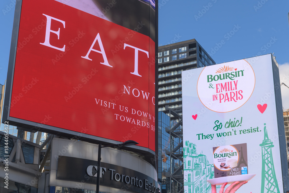 Naklejka premium digital display at Sankofa Square featuring ads for Eataly Eaton Centre and Boursin, cheese product, and Netflix rom-com promotion for 