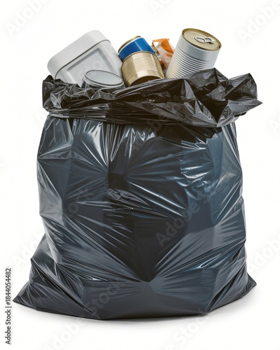 A black plastic garbage bag is filled to the brim with various household waste items. Tin cans and plastic containers poke out from the open top of the sack. 