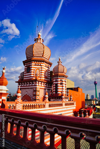 Spectacular view of the historic Minarets of the Jami Ul Alfar Mosque in contrast with the landmark 351m tall Lotus Tower with bright blue skies in Colombo,Sri Lanka