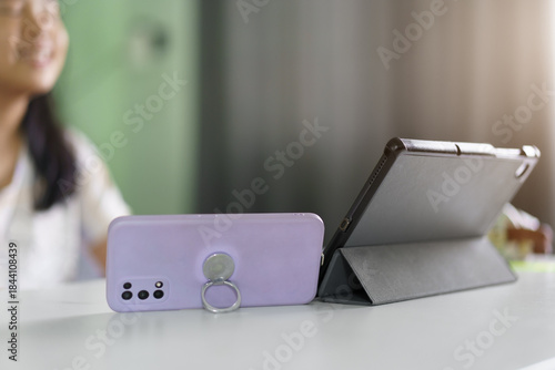 closeup real tablet and smartphone with blur asian child smile or kid girl study online class or fun learning from home school by computer mobile phone or people studying learn by technology education