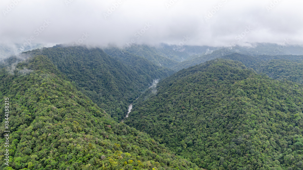 Fototapeta premium Breathtaking aerial view of the lush green mountains in Agua Clara, Valle del Cauca, Colombia, enveloped in mist.