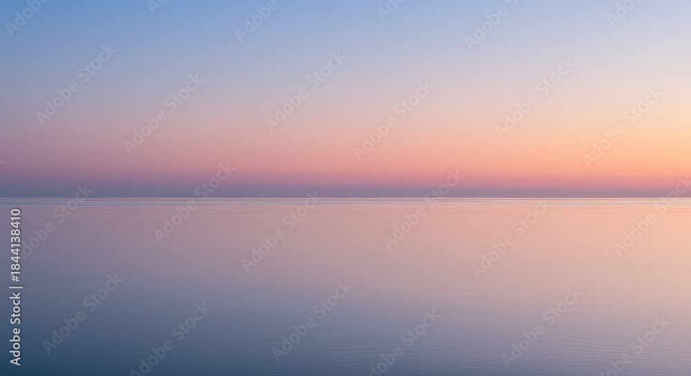 Obraz premium A serene, soft-focus view of a calm body of water at sunrise or sunset. Blending of pastel colors across the horizon