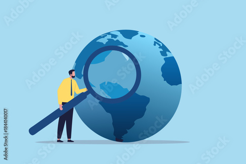A man examines the world through a large magnifying glass