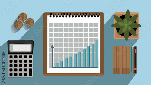 Overhead view of a desk with a graph on a notepad, calculator, coins, plant, and books arranged neatly