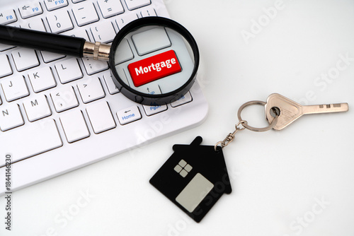 Photos A Red keyboard key labeled 'Mortgage under magnifying glass alongside a house k